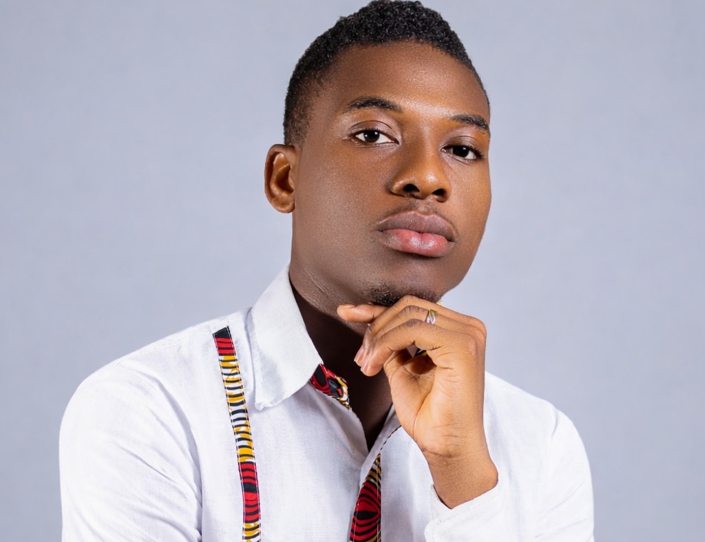 Person posing indoors wearing a light shirt, photographed against a plain background.