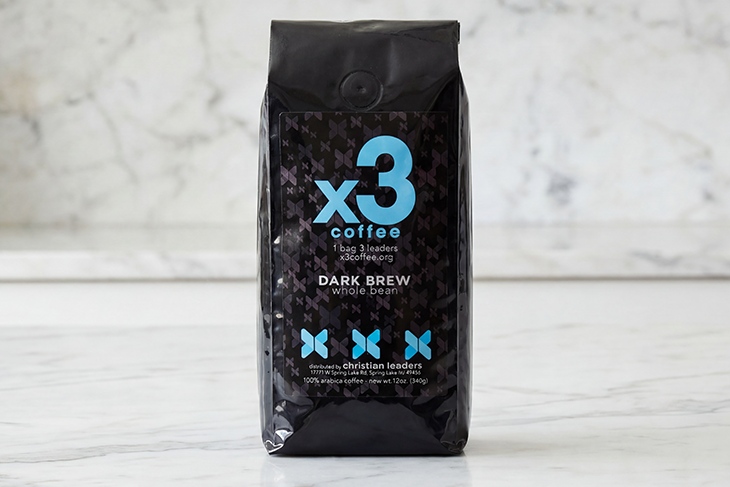 Bag of x3 Coffee Dark Brew whole bean coffee displayed on a light marble surface.