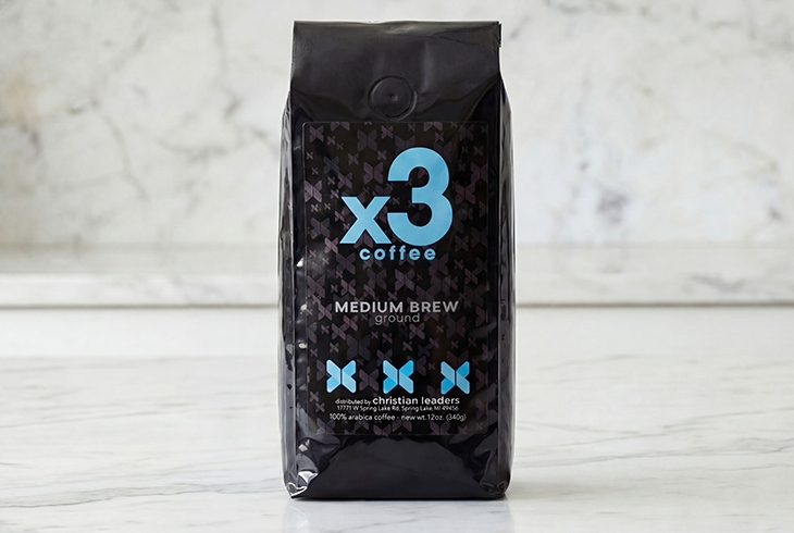 Bag of x3 Coffee Medium Brew ground coffee displayed on a light marble surface.